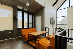 a dining room with orange chairs and a wooden table at Cosy Pool Villa at Khaoyai in Nong Nam Daeng