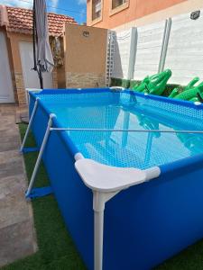 a swimming pool with a table and a chair at La historia de la Casa de los Gatos in Los Narejos