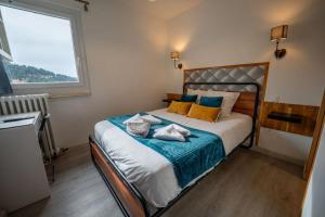 a bedroom with a bed with a blue blanket and a window at Auberge Restaurant du Virage in Chamrousse