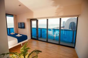 una habitación con una cama y una ventana grande en Fort sea view, en Batumi