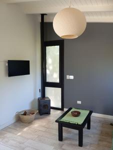 ein Wohnzimmer mit einem Couchtisch und einem TV in der Unterkunft Cabaña Panpachay Villa Giardino in Villa Giardino