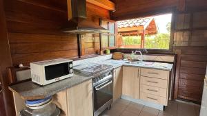 eine kleine Küche mit Mikrowelle und Herd in der Unterkunft Casa de Praia 3 Quartos Mussulo in Luanda + 14 Fotos