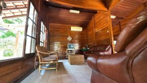 ein Wohnzimmer mit Ledercouch und Fernseher in der Unterkunft Casa de Praia 3 Quartos Mussulo in Luanda