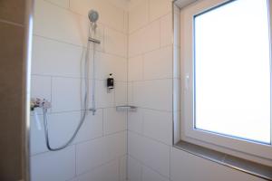 eine Dusche mit Duschkopf und ein Fenster im Badezimmer in der Unterkunft Smart & Stay Aparthotel Saarbrücken Süd - Self-Check-In - Free Parking in Saarbrücken