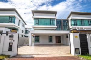 Un gran edificio blanco con una entrada para autos en frente. en Cheekaaboo Playhouse Ipoh, en Ipoh
