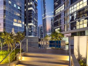 a staircase in a city with tall buildings at Luxury Radiant Boulevard Residence in Mushayrib