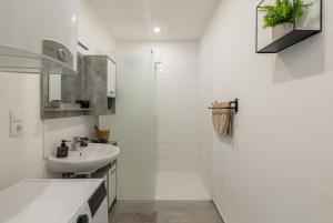 a white bathroom with a sink and a mirror at Secret Collection in Frauenkirchen +32 photos