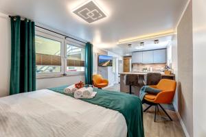 a bedroom with a bed and two chairs and a kitchen at Ferienwohnungen zum Ostseestrand in Ahlbeck