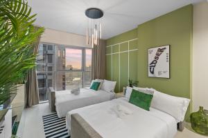 two beds in a room with green walls at Luxury Radiant Boulevard Residence in Mushayrib +35 photos