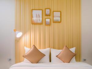 a bedroom with a bed with pillows and pictures on the wall at Louis Residence Hotel in Nakhon Ratchasima +60 photos