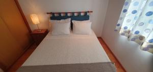 a small bedroom with a bed with a blue headboard at Quinta do Santo no Douro - Casa T3 in Alcarias +19 photos