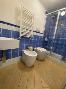 a blue tiled bathroom with a toilet and a bidet at Manu's House B&B in Porto Empedocle