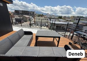 a patio with a table and a bench on a balcony at Room 2type Fuji Trip House Sepia 3F and Deneb 4F in Azagawa