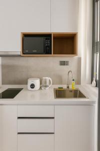 a white kitchen with a sink and a microwave at Rose & Golf at Rose Apple Square in Siem Reap