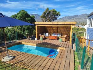 a deck with a pool and a house at The Mermaid's Tail in Pringle Bay