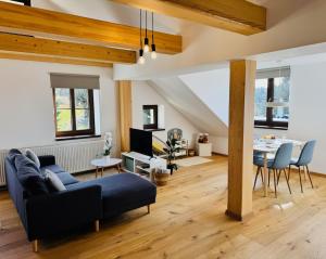 a living room with a blue couch and a table at Nature Apartment in Albrechtice v Jizerských horách
