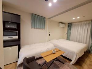 a bedroom with a bed and a table in it at ローズパーク十番館 in Narashino