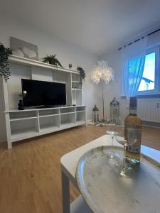 a living room with a tv and a table with wine glasses at Stielvolle Wohnung in bester Lage in Rodenbach