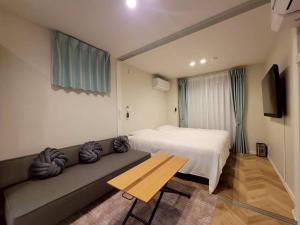 a hotel room with a bed and a couch at ローズパーク十番館 in Narashino