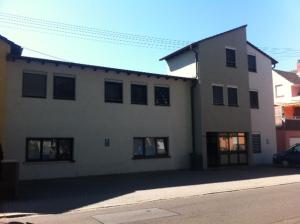 a large white building with black windows on a street at Mayer-Pension in Ludwigshafen am Rhein