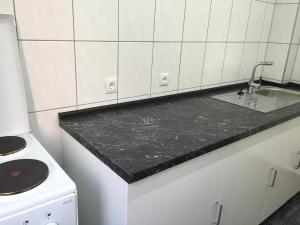 a kitchen with a black counter top and a sink at Mayer-Pension in Ludwigshafen am Rhein