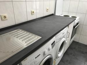 a kitchen with a stove and a washing machine at Mayer-Pension in Ludwigshafen am Rhein