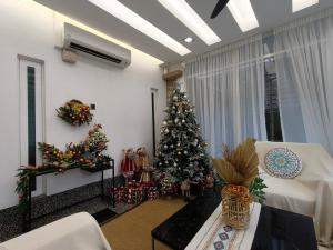 ein Wohnzimmer mit einem Weihnachtsbaum in einem Zimmer in der Unterkunft 25,000sq.ft Grand Luxe Villa PJ 13BR 42Pax By Verano in Petaling Jaya