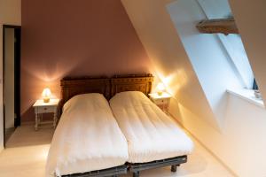 a bed in a room with two lamps on two tables at Maison 2 in Souvigny