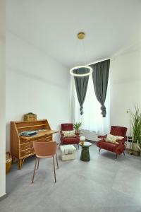 een woonkamer met een piano en rode stoelen bij Apt G 209 in Montepulciano