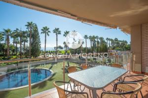 een balkon met een tafel en stoelen en een zwembad bij Vila Dorpesa X-CM in Oropesa del Mar