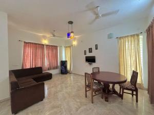 a living room with a table and a couch at Manoj hotel in in Covelong