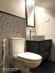 a bathroom with a toilet and a sink and a mirror at Manoj hotel in in Covelong +15 photos