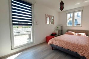 une chambre avec un lit et une grande fenêtre dans l'établissement Résidence Abyssia, à Ensisheim
