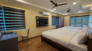 a bedroom with a large bed and a tv at Lakshmi Narayana Grand in Kanchipuram