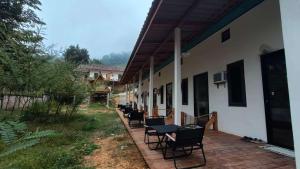 a patio with chairs and tables on a building at NongKhiaw Mimosa Dormitory in Nongkhiaw