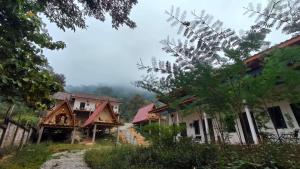 a group of houses on a dirt road in a village at NongKhiaw Mimosa Dormitory in Nongkhiaw +4 photos