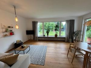 a living room with a couch and a table at Idyllische Wohnung mit Bergblick nah am Simssee in Stephanskirchen