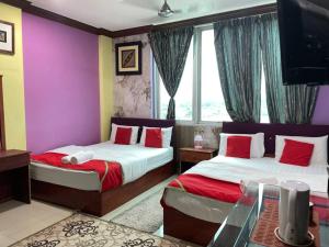 a hotel room with two beds and a tv at Saujana City Hotel - Nearby KLIA in Bandar Saujana Putra +67 photos