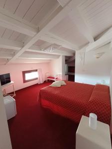 una camera con un letto rosso e un tappeto rosso di Villa Marini Trevisan ad Aviano