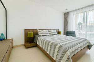 a bedroom with a large bed and a window at Rose & Golf at Rose Apple Square in Siem Reap