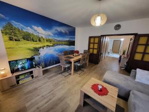 una sala de estar con una gran pintura de un lago en Apartmán Juli, en Horní Planá