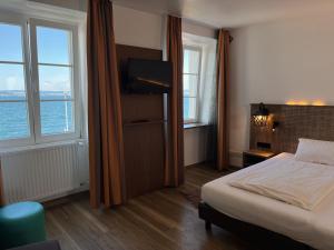 a hotel room with a bed and two windows at Hotel Restaurant Alte Post in Meersburg