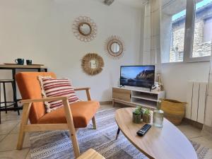 un salon avec une chaise et une télévision dans l'établissement Le Vercors, à Chabeuil 3 autres photos