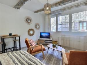 un salon avec un lit et une télévision dans l'établissement Le Vercors, à Chabeuil