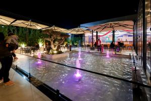 a pool of water with fountains in a building at Si'Hana Hotel in Elbasan