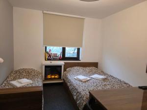 una camera da letto con due letti e un camino di Snow White apartman Vila Bela reka 50m from gondola - free parking a Brzeće