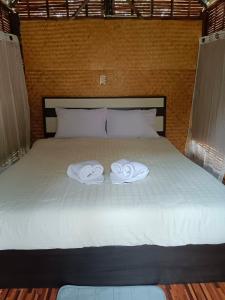 a bed with two towels on top of it at Paivana Khaosok Village in Khao Sok