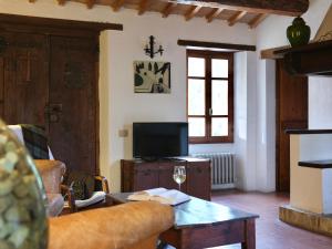 a living room with a couch and a tv at Palazzo Di Bagnaia in Castel del Piano