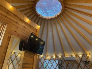 a room with a tv in a ceiling with a window at Pala Chino Yurt - Next to Nantahala Weddings in Aquone