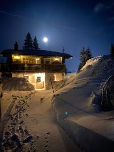 Sälen Gruvens fäbod في سالن: منزل به آثار أقدام في الثلج في الليل
